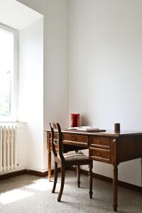 drewnianym biurkiem z krzesłem obok okna w obiekcie Residenza IL COLLE w mieście Subiaco