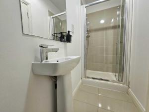 uma casa de banho com um lavatório e um chuveiro em Bee Accommodations Backways em Leicester