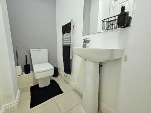 uma casa de banho branca com um lavatório e um WC em Bee Accommodations Backways em Leicester
