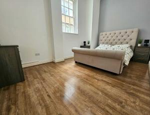 uma sala de estar com um sofá e um piso de madeira em Bee Accommodations Backways em Leicester