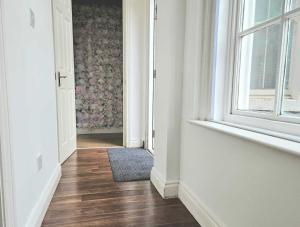 an empty hallway with a window and a rug at Bee Accommodations Backways in Leicester