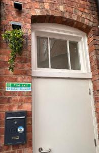 uma porta branca e uma janela num edifício de tijolos em Bee Accommodations Backways em Leicester