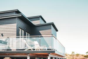 uma casa preta com uma varanda de vidro em HavsVidden Resort em Geta