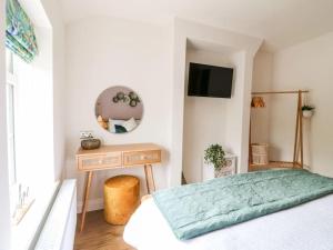 a bedroom with a bed and a table and a television at Minster Cottage - Cathedral Quarter with Permit Parking in Lincoln
