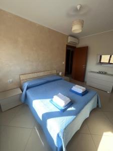 een slaapkamer met een blauw bed met 2 handdoeken erop bij Vacanze vista mare in Montesilvano