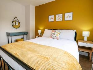 a bedroom with a white bed and a yellow wall at Minster Cottage - Cathedral Quarter with Permit Parking in Lincoln