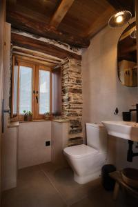 a bathroom with a toilet and a sink at Lar da cima in Folgoso