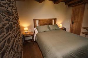 Lar da cima في Folgoso: غرفة نوم بها سرير ومصباحين على الطاولات