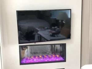 a flat screen tv hanging on a wall at 3 Quay Cottage Killala. Luxury Sea-Front Cottage in Killala