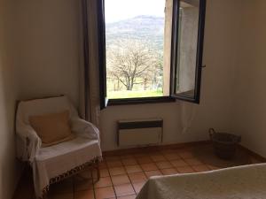 a room with a chair and a window with a view at La belle étoile in La Palud sur Verdon