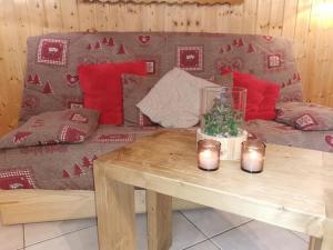 sala de estar con sofá y mesa con velas en Demi-Chalet l'Ancolie -- Prox pistes, en Les Carroz d'Araches