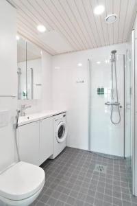 a white bathroom with a toilet and a shower at Norden Homes 2-Bedroom Apartment in Turku