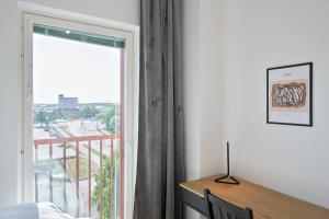 a bedroom with a window with a view of a balcony at Norden Homes 2-Bedroom Apartment in Turku