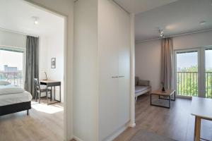 a bedroom with a bed and a living room with a table at Norden Homes 2-Bedroom Apartment in Turku