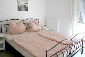 a bedroom with a bed with pink sheets and pillows at Görg Ferienwohnungen in Kröv