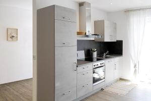 a kitchen with white cabinets and a stove at Görg Ferienwohnungen in Kröv