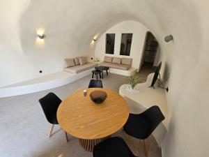 um quarto com uma mesa e cadeiras e um sofá em Petroma Cave Suites em Vourvoúlos