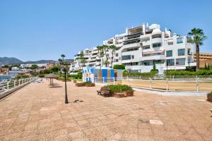 un gran edificio blanco con palmeras y luz de la calle en Santa Clara, en Torremolinos