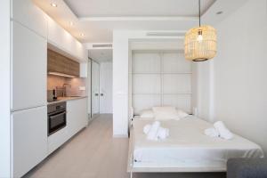 Un dormitorio blanco con una cama y una cocina. en Santa Clara, en Torremolinos