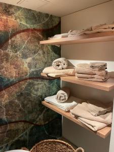 una habitación con estanterías con toallas y una pared en Luxuriöses Loft mit großer Sonnenterrasse & Sauna, en Múnich