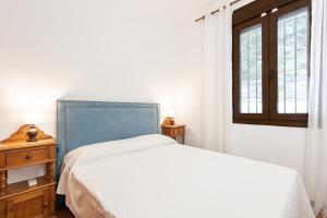 ein Schlafzimmer mit einem weißen Bett und einem Fenster in der Unterkunft The Gardener Cottage in Málaga