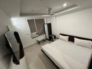 um quarto com uma cama e uma televisão em Hotel Shree A unit of THC Group em Kota