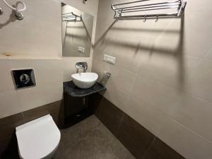 uma casa de banho com um WC branco e um lavatório. em Hotel Shree A unit of THC Group em Kota