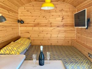 a sauna with two tables and a bottle of wine at Cwt y Bugail in Barmouth