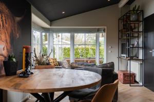 ein Wohnzimmer mit einem Tisch und einem Sofa in der Unterkunft Het Verwende Nest met privé Hottub & tuin in Voorthuizen