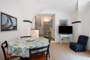 a dining room with a table and a television at Oceane Paradise - Luigi 14 in Levanto