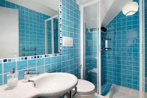 a blue tiled bathroom with a sink and a toilet at Oceane Paradise - Luigi 14 in Levanto +20 photos