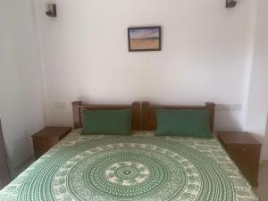 1 dormitorio con 1 cama grande con almohadas verdes en MILLET'S FOOD COMPANY AND COOKING CENTER, en Negombo