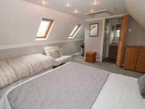 a bedroom with a bed and a chair at The Coach House in Whitmore