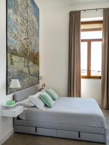 een slaapkamer met een bed met een schilderij aan de muur bij Vecchi Maestri Bed & Breakfast in Arcevia