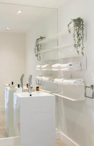 een witte badkamer met 2 wastafels en een spiegel bij Vecchi Maestri Bed & Breakfast in Arcevia
