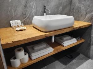 um lavatório de casa de banho numa prateleira de madeira com toalhas em K2 home em Bormio