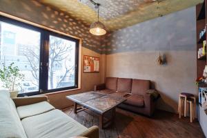un soggiorno con un divano e un tavolo di Untapped Hostel a Sapporo