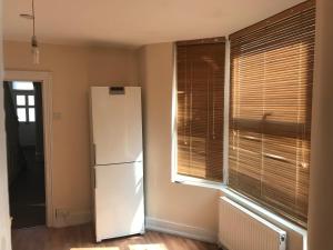 a white refrigerator in a room with a window at The Griffen Lodge in Plumstead