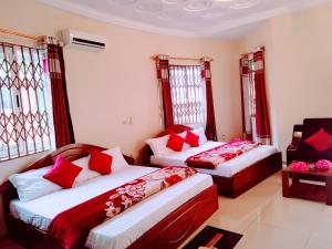 1 dormitorio con 2 camas y almohadas rojas en Room in Apartment - Renajoe Ejisu-Kubease, en Kubeasi