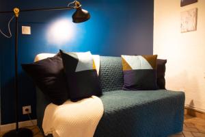niebieski pokój z kanapą z poduszkami w obiekcie Petit Studio Secret - Coeur de Provence - 4 personnes w mieście Volx