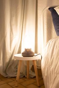 a lamp sitting on a table next to a bed at Petit Studio Secret - Coeur de Provence - 4 personnes in Volx