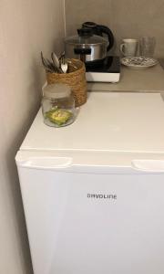 a white refrigerator with a basket on top of it at Solo traveler in Ermoupoli