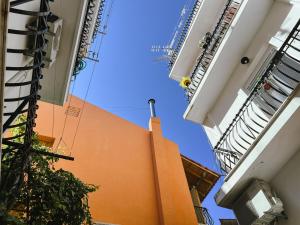 an orange building with a fire hydrant between two buildings at Theo's Apartment in Argostoli