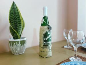 a bottle of wine sitting on a table with a plant at Theo's Apartment in Argostoli