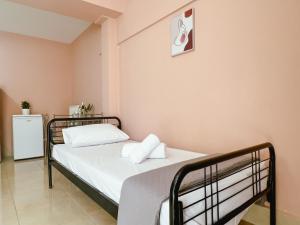 a bedroom with two beds and a refrigerator at Theo's Apartment in Argostoli