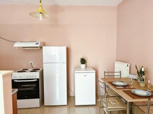 a kitchen with a white refrigerator and a table at Theo's Apartment in Argostoli