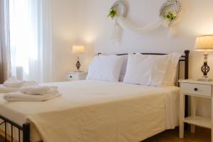 une chambre blanche avec un lit avec des draps et des oreillers blancs dans l'établissement Savvitsa's Apartment, à Corfou 20 autres photos