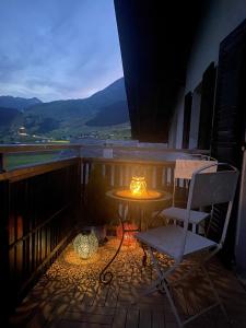 eine Terrasse mit einem Tisch und einem Stuhl auf dem Balkon in der Unterkunft Apartment Margherita in Sedrun