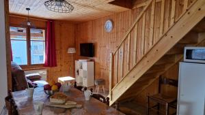 Habitación de madera con mesa y escalera en Appartement L'Ecureuil 8 pers -Prox pistes et centre village-, en Les Carroz d'Araches