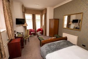 a hotel room with a bed and a mirror at Castle and Ball by Greene King Inns in Marlborough